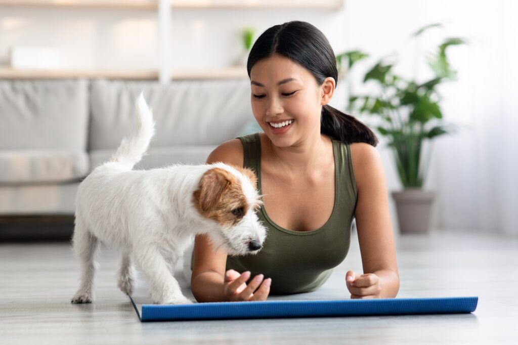 fluffy puppy exercising with its owner sporty asian lady