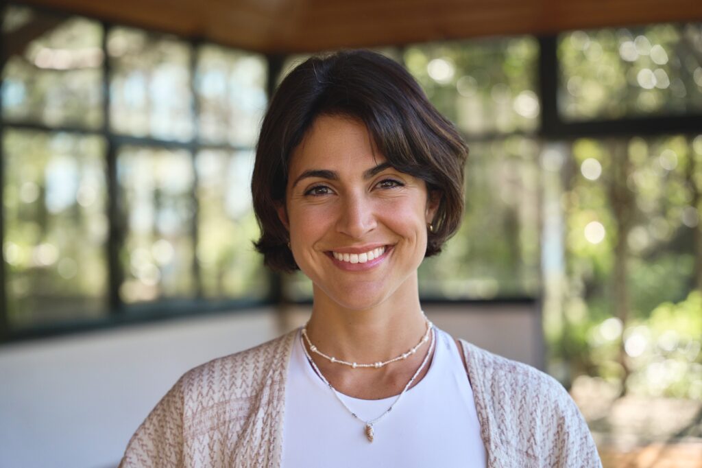 young happy hispanic woman holistic teacher looking at camera in yoga studio